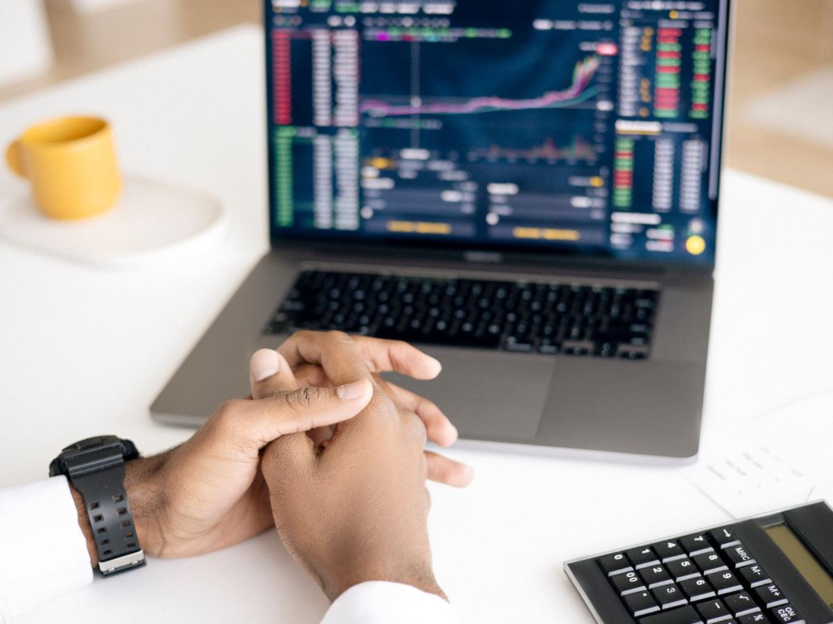Hände vor einem Laptop mit Finanzdaten